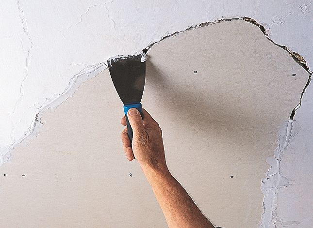 Hình ảnh công nhân đang sửa chữa một phần trần thạch cao bị hỏng